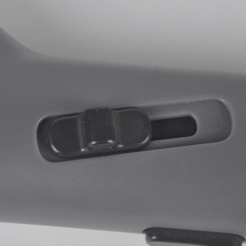 Close-up of a gray vehicle seat with a black buckle mechanism.